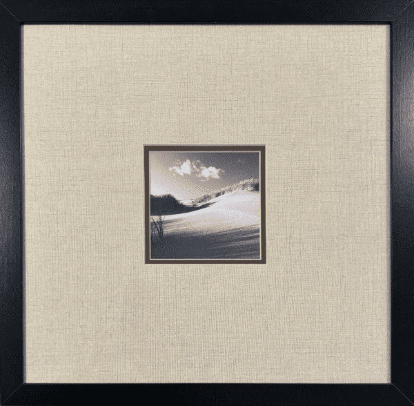 untouched stillness of a sandy landscape, where soft dunes stretch into the distance under a quiet sky. The grainy texture of the sand contrasts with the smooth cloud formation above, creating a striking balance between earth and sky.